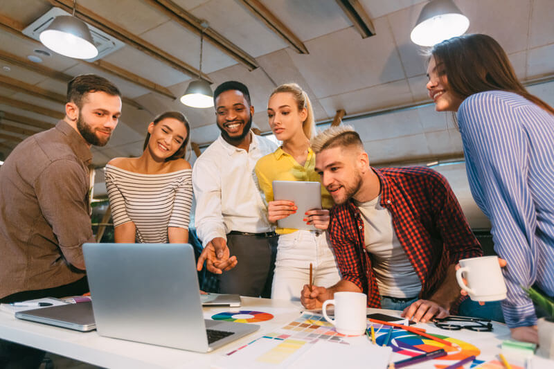 group of marketing professionals around a laptop computer