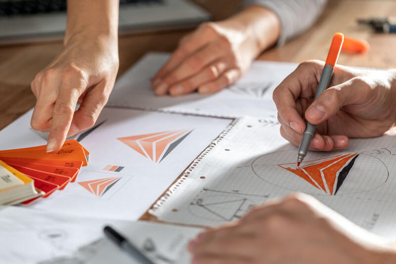closeup of hands holding pen to design logo