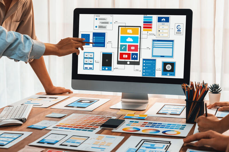 desktop with computer surrounded by marketing materials