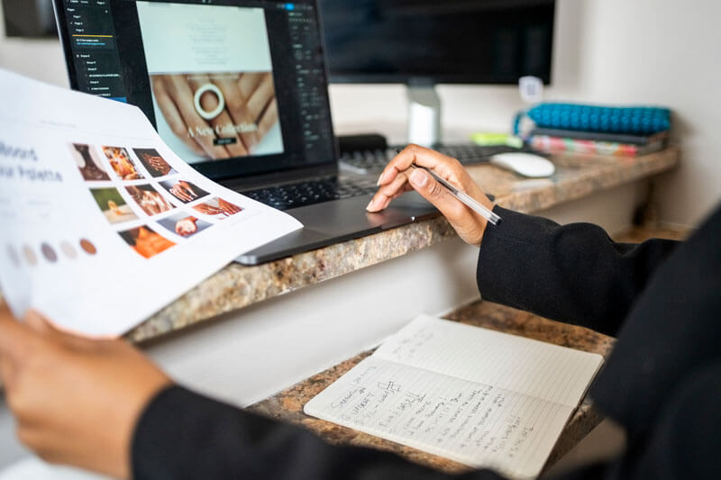 closeup of hands working on a laptop with marketing materials